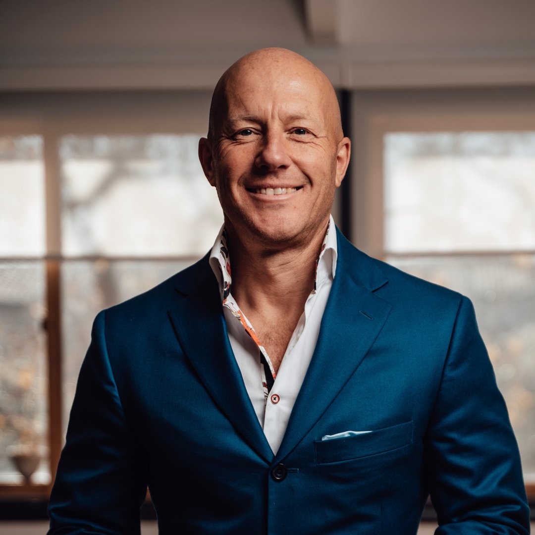 Professional headshot of a man in a blue suit