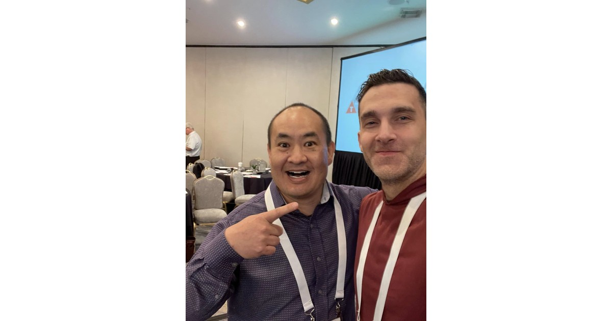 Dennis Yu and Ryan Skelly taking a selfie together at a marketing conference